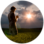 Person in prayer and contemplation at sunrise, bathed in golden light symbolizing peace and divine connection.