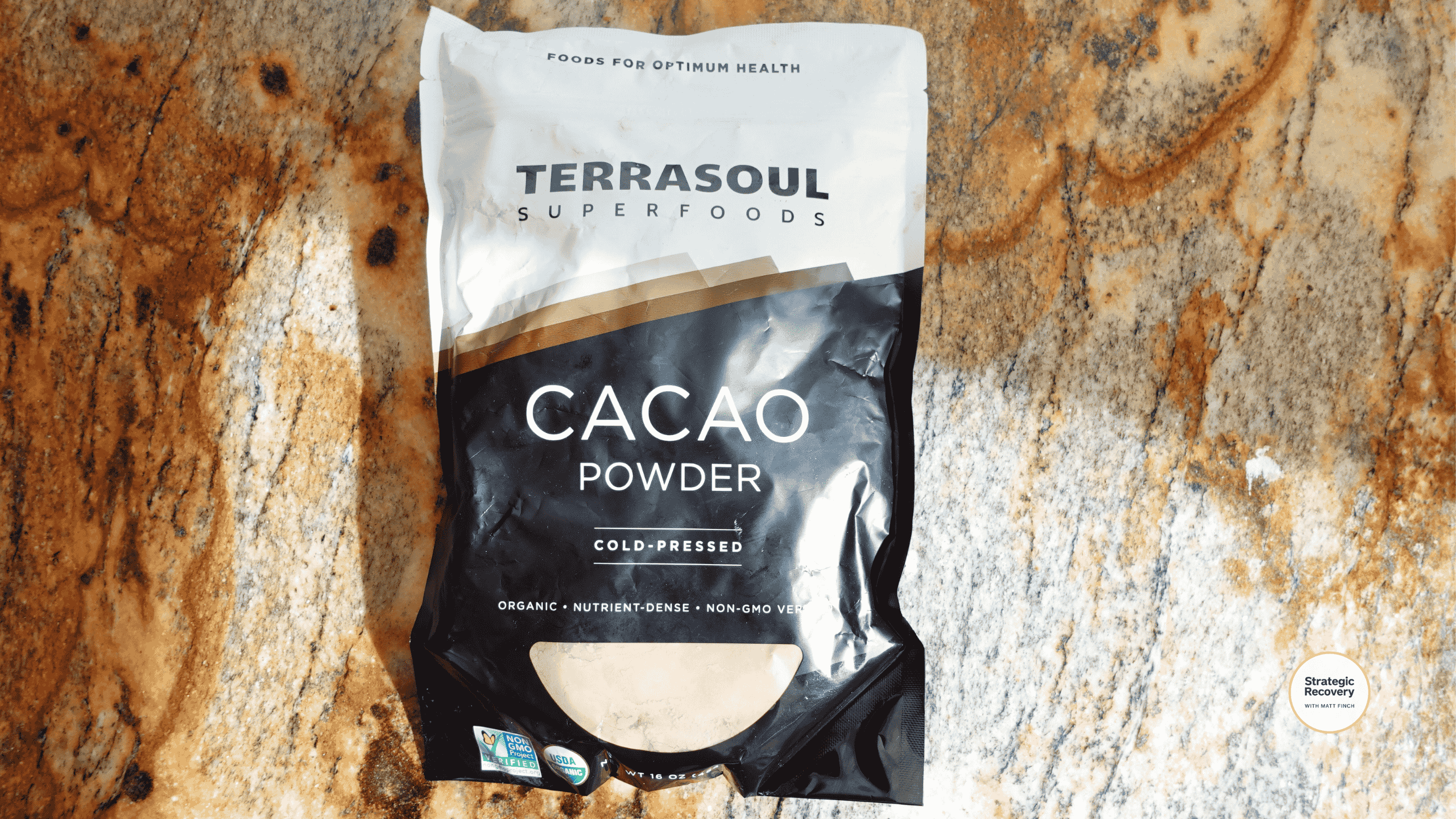 Rich brown raw organic cacao powder in a scoop, ready to blend into a drink